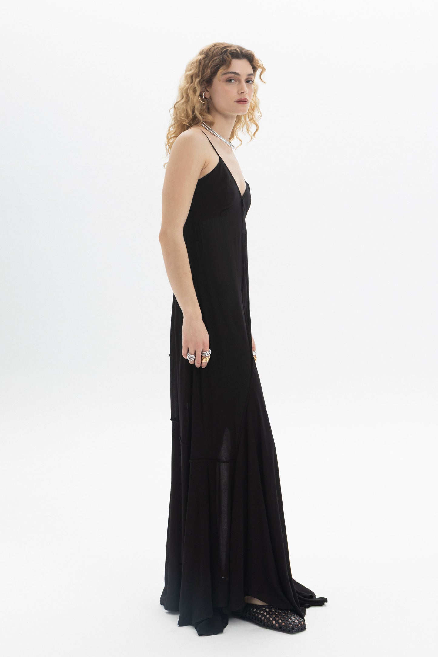A model wearing a V-Neck Maxi Dress featuring a flowing tiered hem and thin straps, perfect for a relaxed fit.