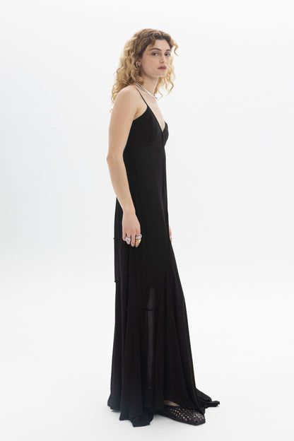 A model wearing a V-Neck Maxi Dress featuring a flowing tiered hem and thin straps, perfect for a relaxed fit.