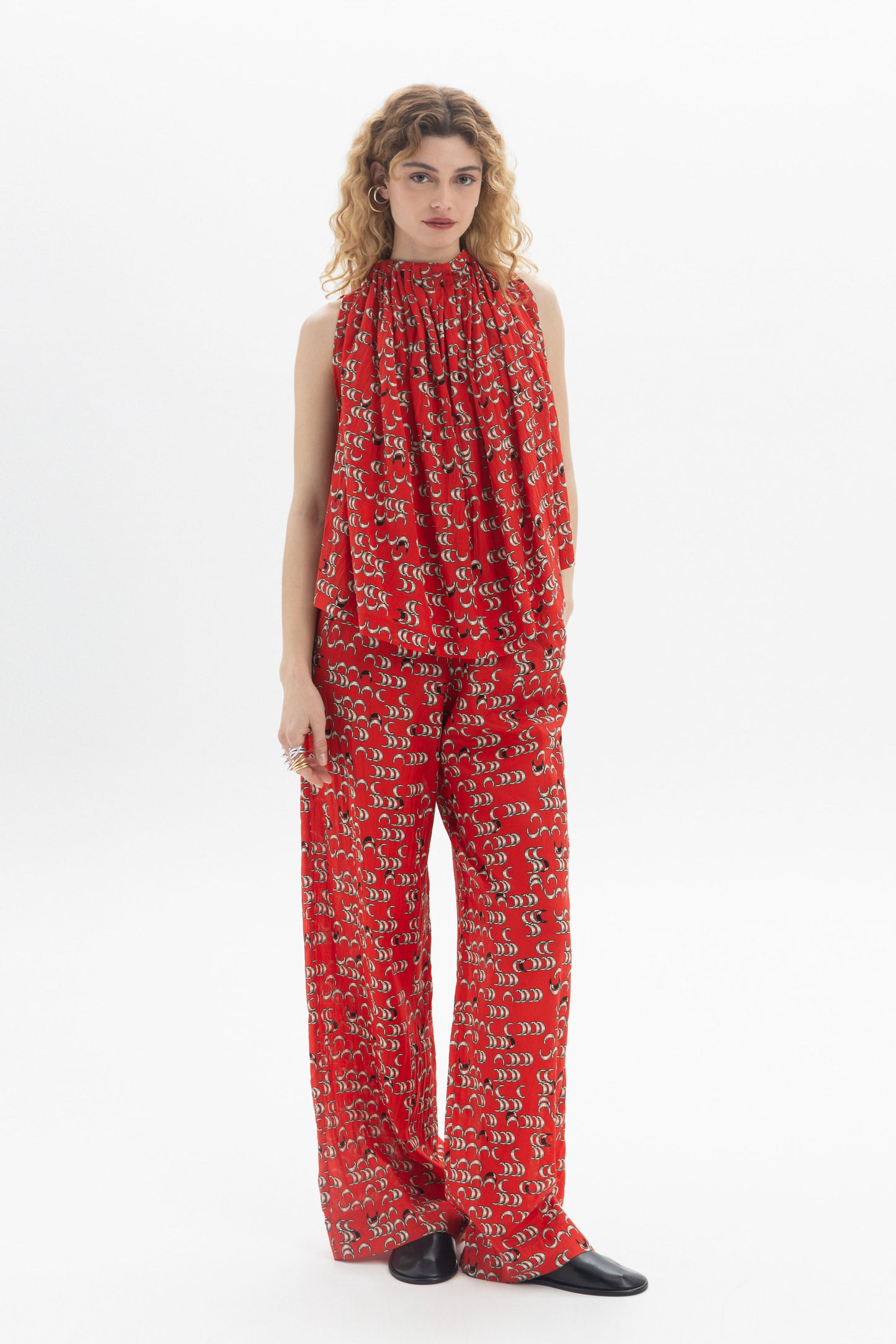 Model wearing relaxed straight-leg pants in a vibrant red print, showcasing the modern and stylish design.