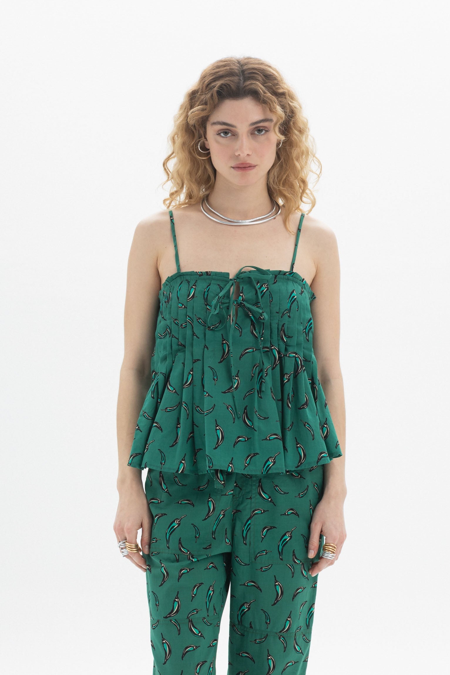Woman wearing a Tie Front Cami with gathered neckline and green chili pepper print, paired with matching pants.