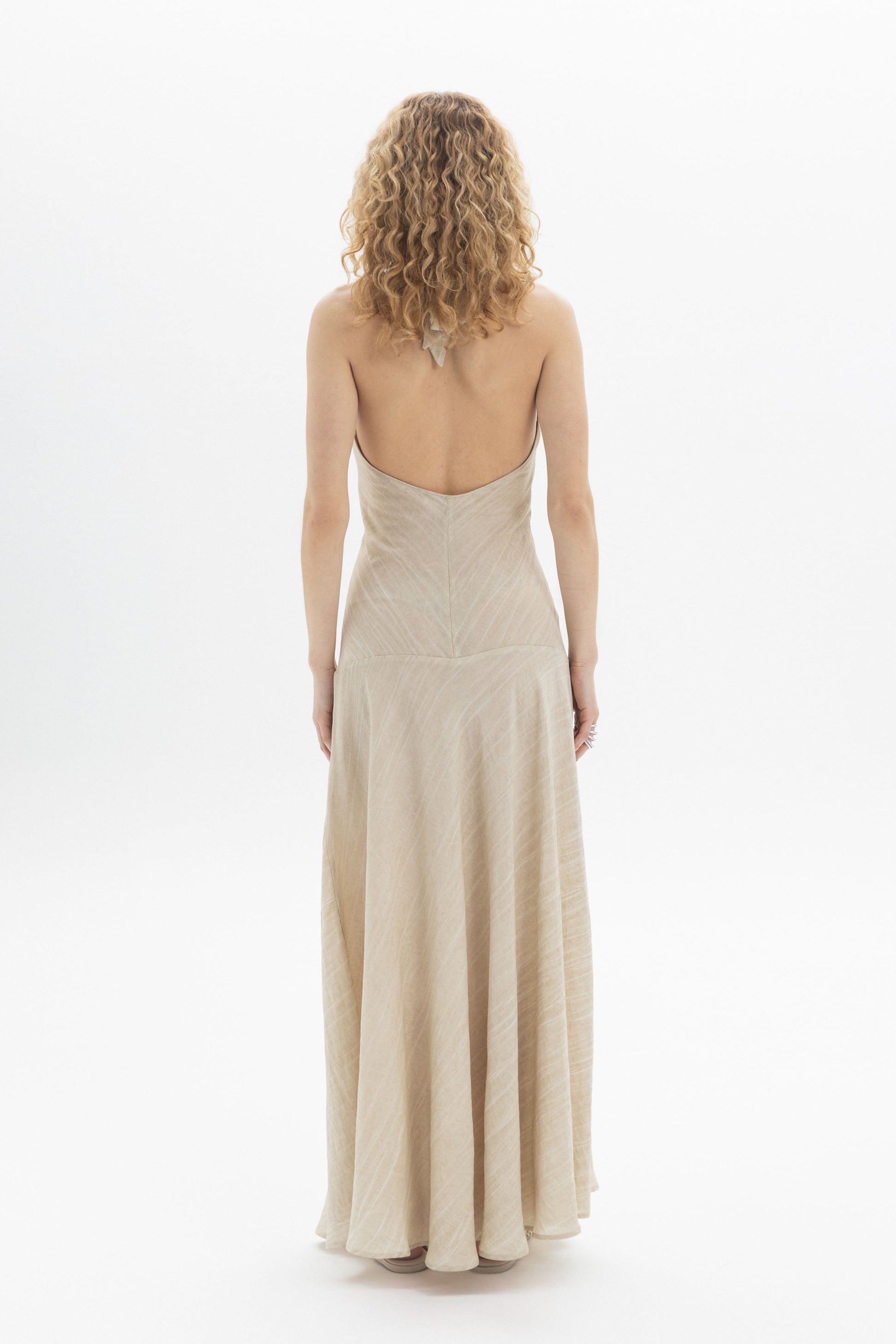 Halter Maxi Dress viewed from the back, showcasing the fluid skirt and open back design.
