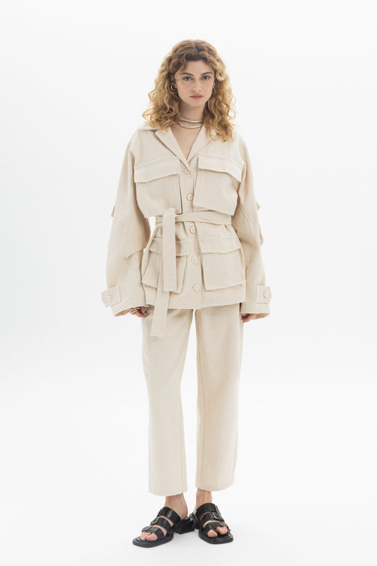 Belted Denim Utility Jacket worn by model, featuring structured collar and multiple flap pockets.