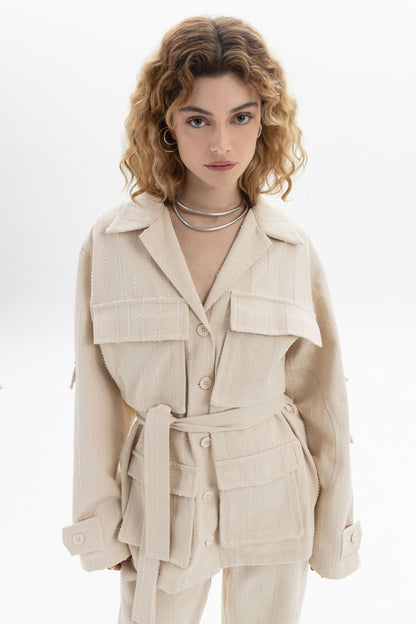 Belted Denim Utility Jacket in a light cream color featuring structured collar and multiple flap pockets.