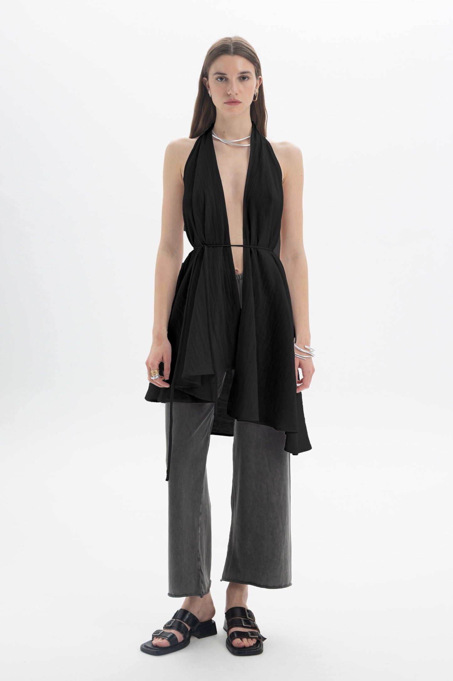 Model wearing a Longline Halter Top with open neckline and flowing draped panels, styled with wide-leg pants.