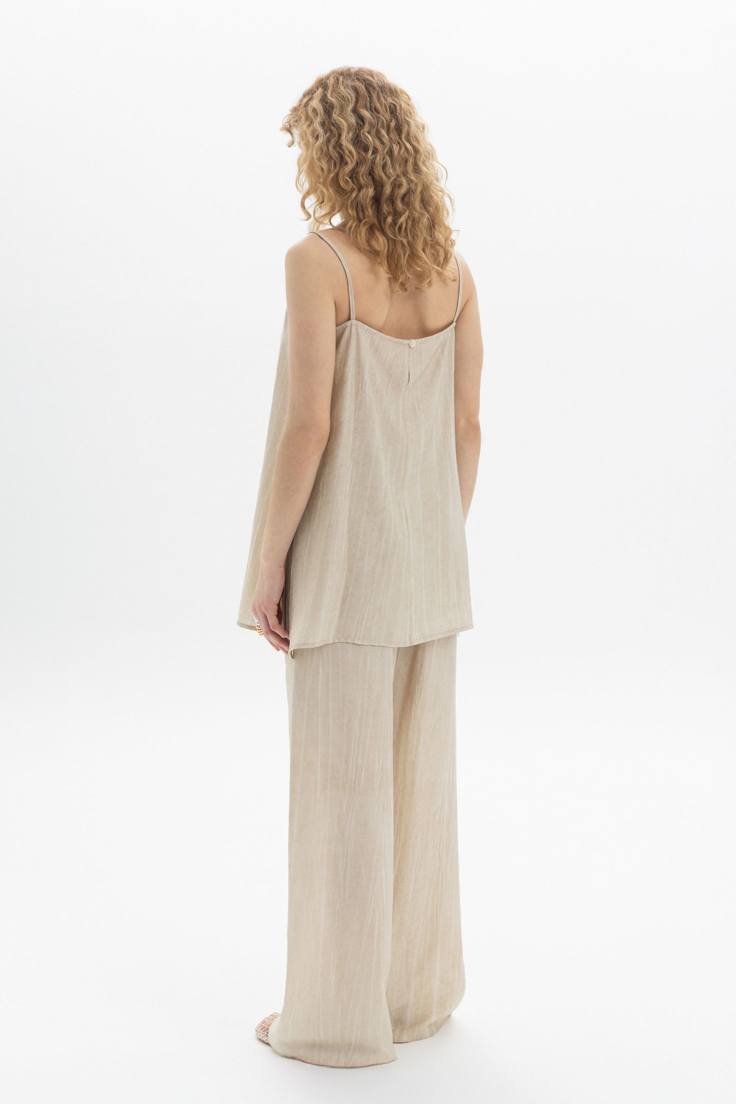 Woman wearing Fluid Cami with slim shoulder straps and relaxed silhouette, paired with matching pants.