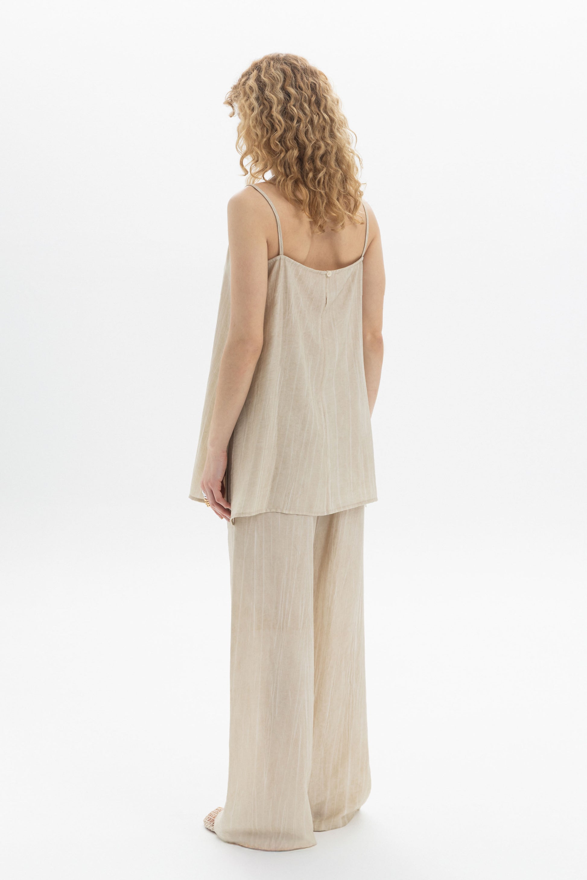 Woman wearing Fluid Cami with slim shoulder straps and relaxed silhouette, paired with matching pants.
