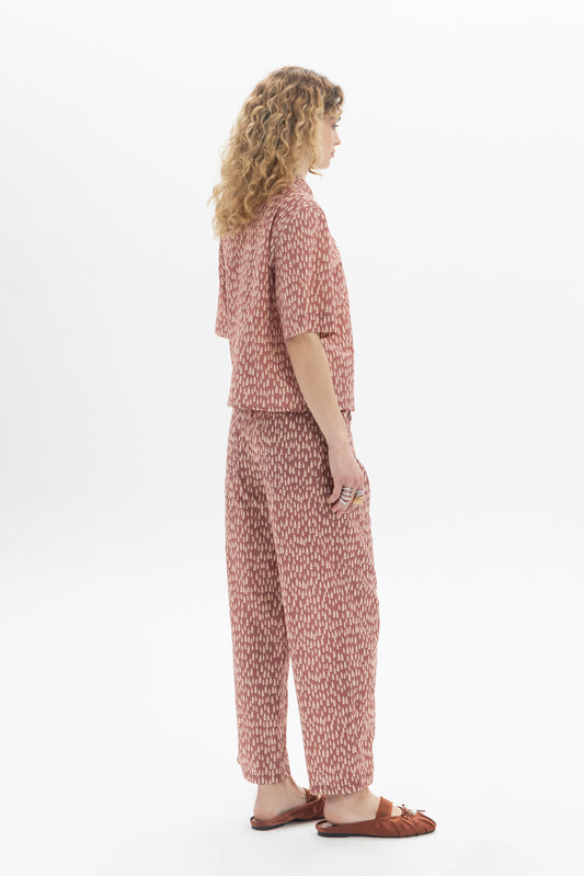 Side view of a woman wearing a Short Sleeve Shirt with abstract drop print and relaxed fit.